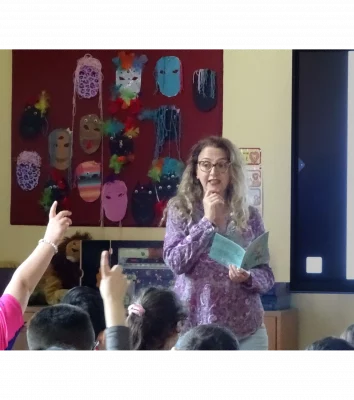 Die Autorin steht in einem Klassenraum vor den Kindern.