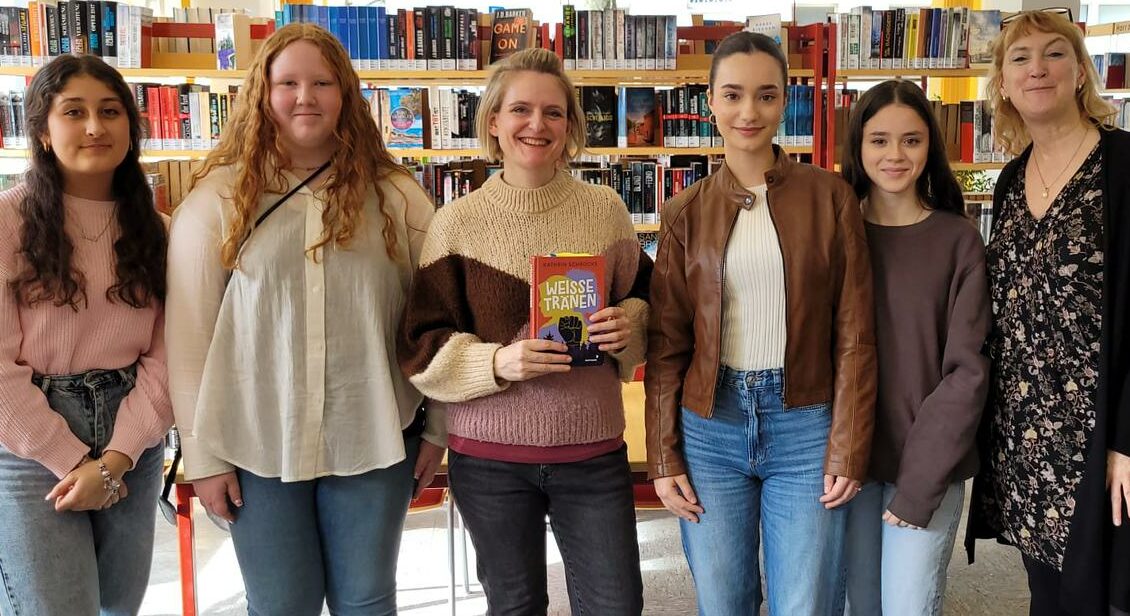Die Autorin Kathrin Schrocke mit Schülerinnen in der Stadtteilbibliothek Frohnhausen