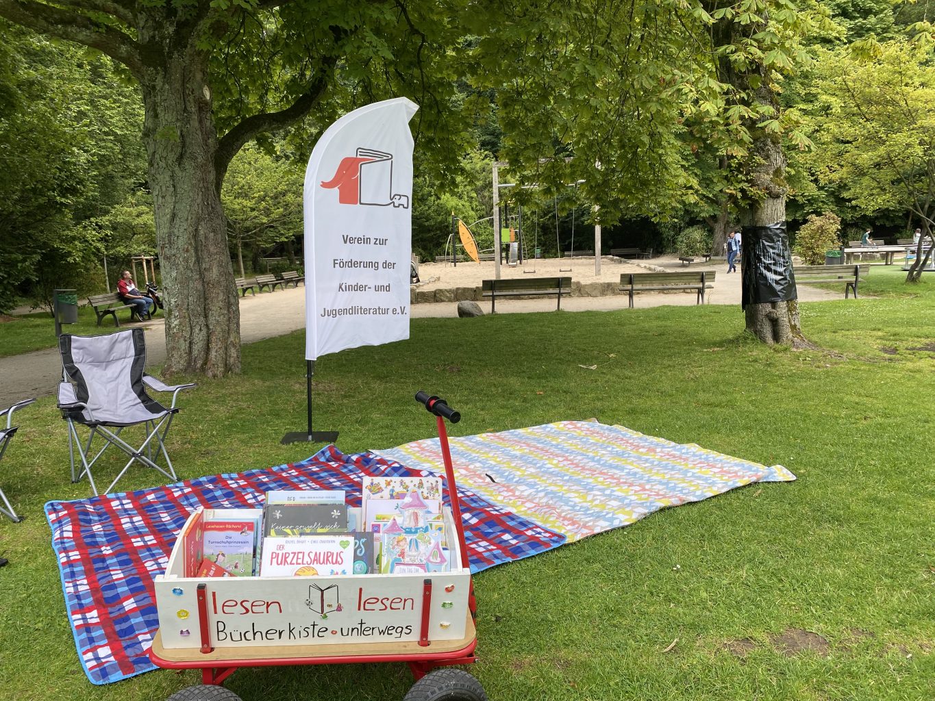 Lesung im Schlosspark Borbeck; Decken und Bollerwagen vor Kinderspielplatz