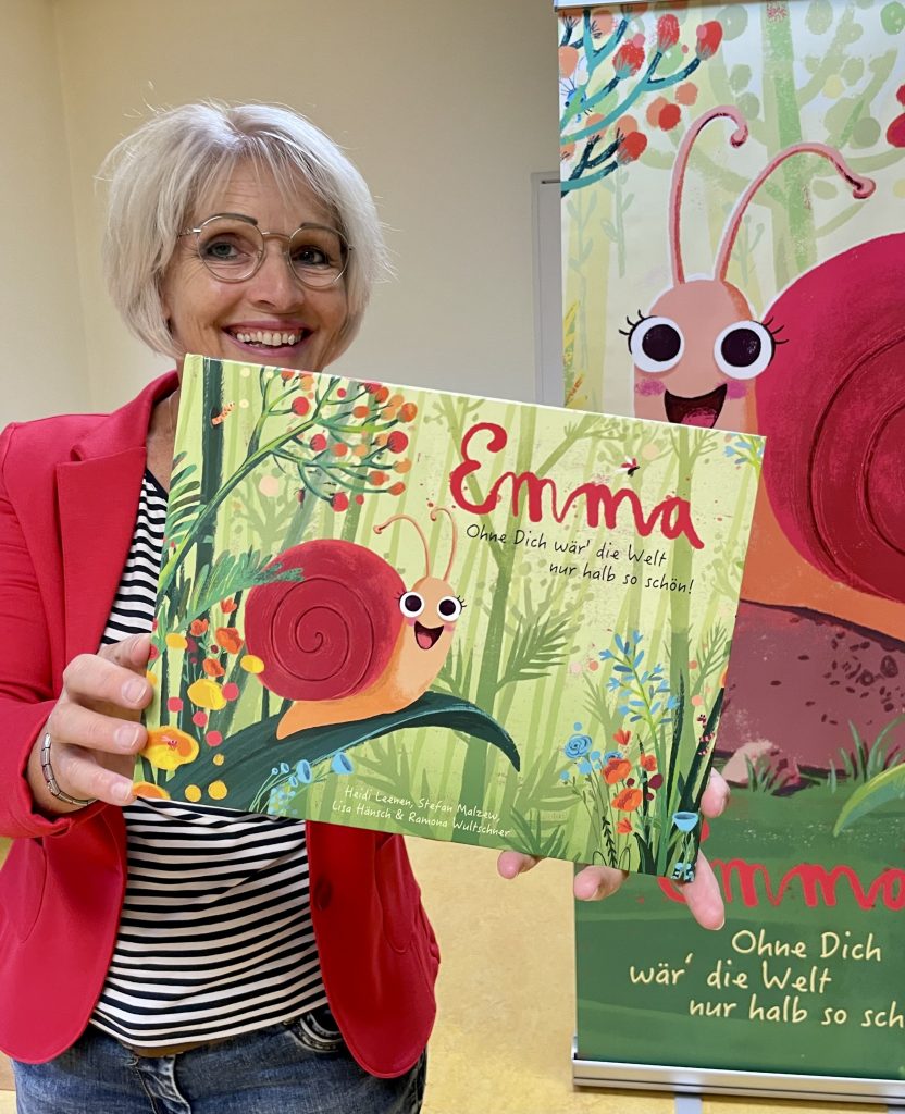 Autorin Heidi Leenen hält ein Buch über die Schnecke Emma in der Hand