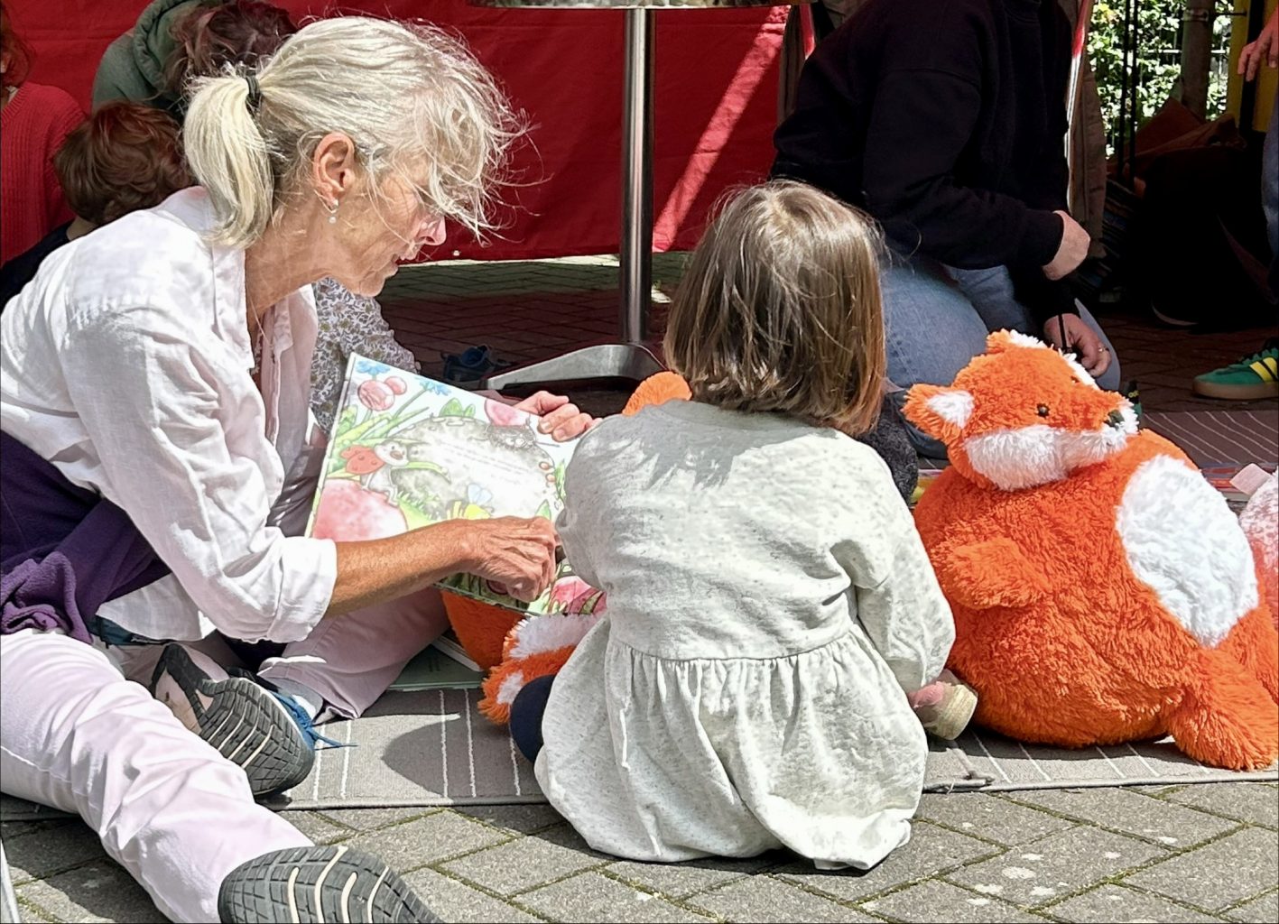Frau liest kleinem Mädchen vor;